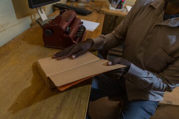 Close-up of a blind man holding a braille book resting on the table: braille reading session