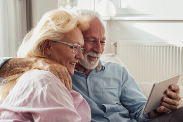 Senior couple talking on video call on tablet at home