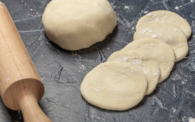 ball of fresh raw dough, flour and rolling pin top view