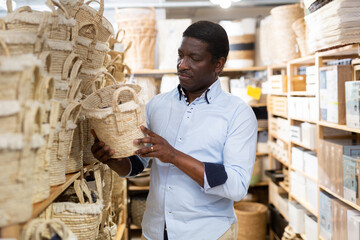 African american man buying wicker basket in a household goods store