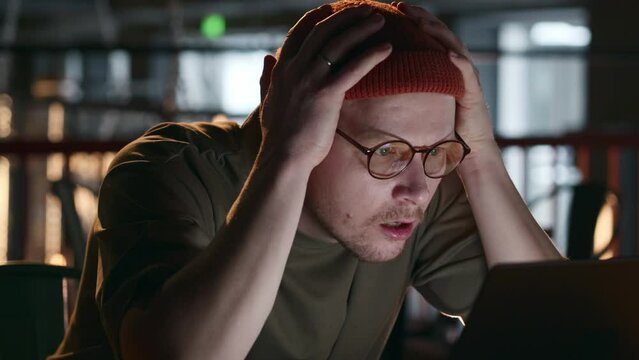 A software engineer has found errors or bugs in the program code and is very disappointed, swears and grabs his head with his hands. The programmer swears at someone else's code. High quality 4k