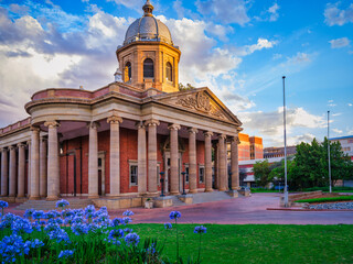 Fourth Raadsaal historic building with garden and flowers during sunset, Free State, Bloemfontein,...