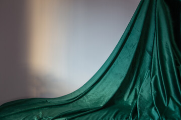 green velvet curtain and gray wall in sunlight - obrazy, fototapety, plakaty