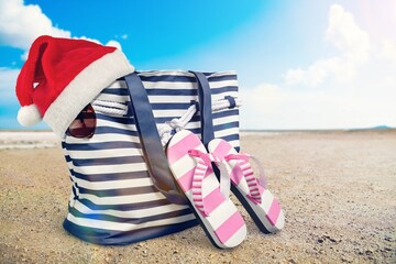 Naklejka premium Santa hat with summer accessories on beach.