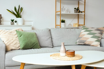 Vase with candle on coffee table in light living room