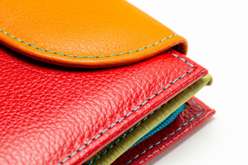 Close-up of a red and orange leather wallet stitched with blue thread. High-quality leather texture...