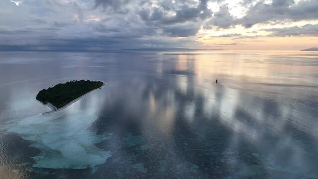 A serene sunrise illuminates the remote island of Koon near Seram, Indonesia. This scenic island's coral reefs, and the surrounding seas, support extraordinary marine biodiversity.