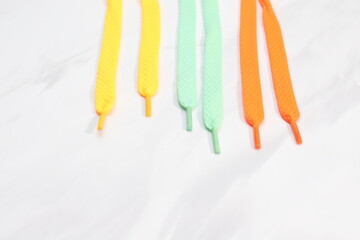 Many shoe laces different colors on marble background