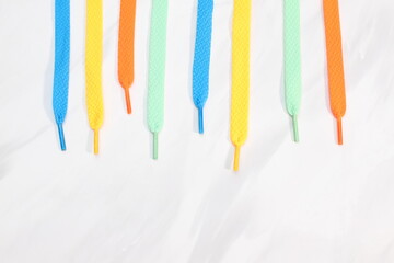 Many shoe laces different colors on marble background