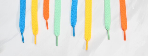 Different color shoe laces on white background, banner design