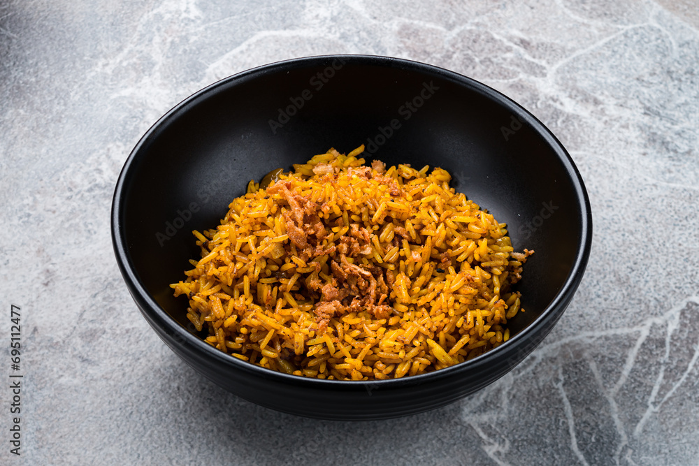 Poster boiled rice with fried onions and curry in a bowl, asian dinner.