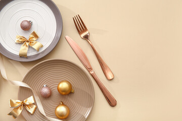 Beautiful table setting with Christmas balls and bows on beige background