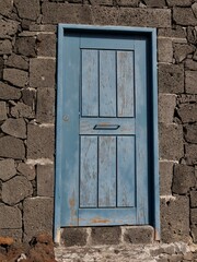 Blaue Holztür im Felsen