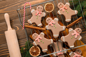 Stand with Christmas sweet gingerbread cookies and candy cane on wooden background