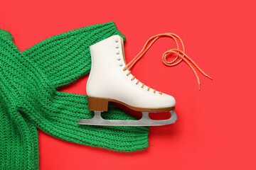 White ice skate and sweater on red background