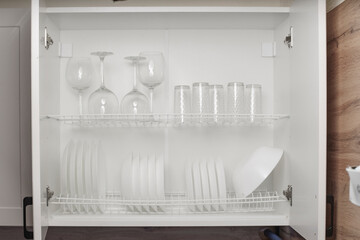utensils in a kitchen. kitchen interior. furniture in the kitchen. clean glass and mugs. vine glasses and cupboard. white background on the kitchen. isolated cup and glass. home kitchen and furniture.