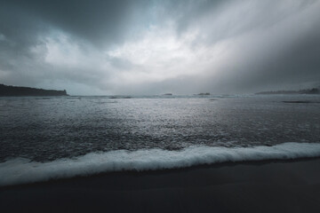 Water rushes up onto a rainy shore in British Columbia.