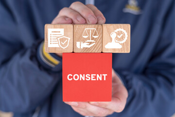 Man holding multi-colored blocks with icons sees word: CONSENT. Medical informed consent concept....