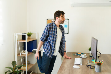 Handsome man doing workout exercises at work