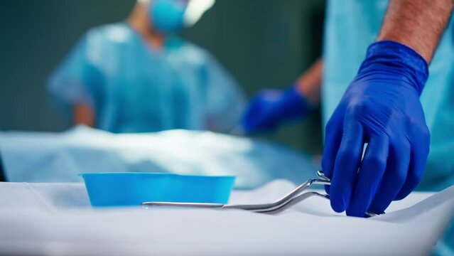 Close-up shot of sterilized scalpels and other metal instruments for surgery on table in an operating room
