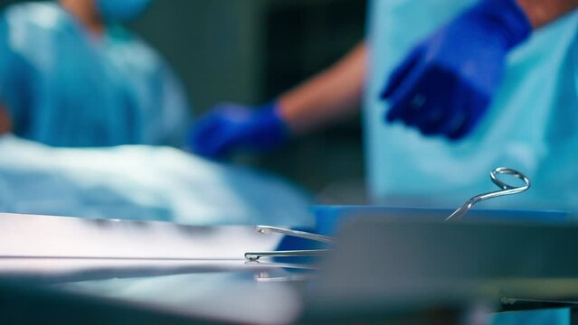 Close-up shot of sterilized scalpels and other metal instruments for surgery on table in an operating room