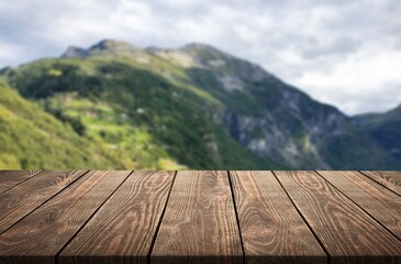 The empty wooden desk top with background of mountains