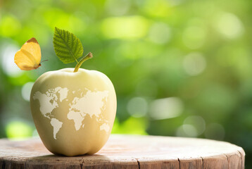 World food day concept: Golden Delicious apple fruits on nature background and world map icon.
