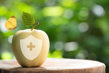 World food day concept: Golden Delicious apple fruits on nature background and health safety icon.