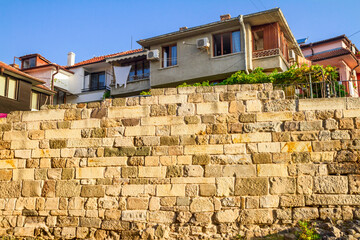 City landscape - Old fortress wall on the background of the city houses, town of Sozopol on the...