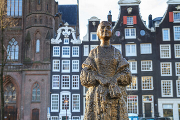 Obraz premium Cityscape - the statue Vrouw met Stola (Woman with stole) is located next to the Siegel canal in the historic center of Amsterdam, the Netherlands