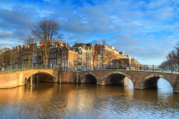 Cityscape on a sunny winter day - view of the bridges and canals in the historic center of Amsterdam, The Netherlands