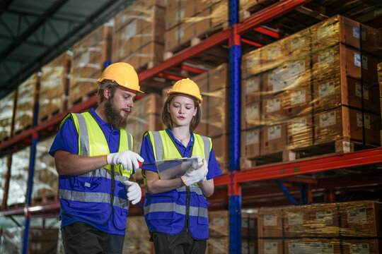 workers checking and inspecting metal machine part items for shipping. male and woman checking the store factory. industry factory warehouse. The warehouse of spare part for machinery and vehicles.