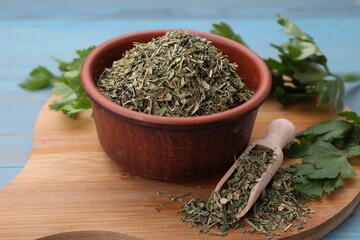 Dried parsley and fresh leaves on light blue table, closeup
