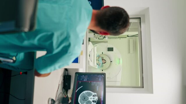 A girl lies on an MRI machine before examining her body and the radiologist gives command to her to prepare for diagnosis