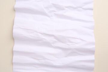 Sheet of crumpled parchment paper on beige background, top view