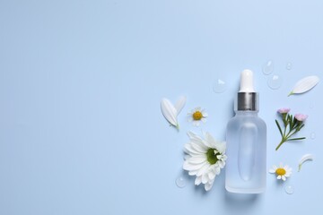 Obraz na płótnie Canvas Bottle of cosmetic serum, flowers and petals on light blue background, flat lay. Space for text