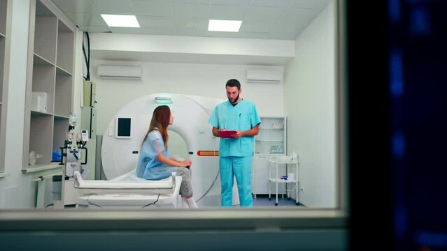 Monitors with diagnostics against the background of a doctor communicating with patient before computed tomography examination
