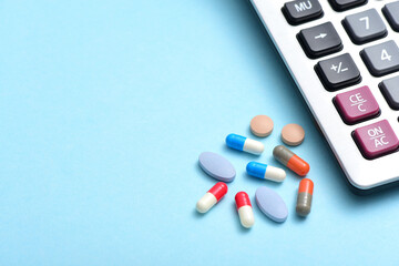 A pile of drugs placed next to the calculator on a blue background