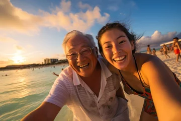 Fotobehang grandfather and granddaughters having a good time on beach at sunset, Okinawa, Japan © sirisakboakaew