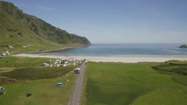 Birds-eye view of beautiful Maloy beach and camping site in Norway. A idyllic coastal landscape with a serene beach and azure water.