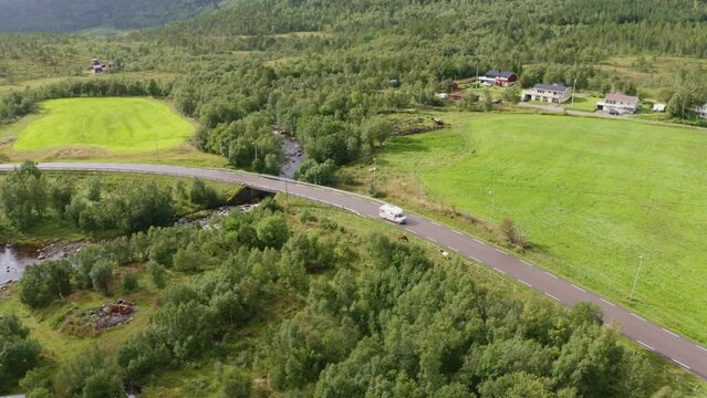 Tourists travelling in a classic motorhome through scenic Norwegian landscapes. A vintage RV driving on the roads in Lodingen.