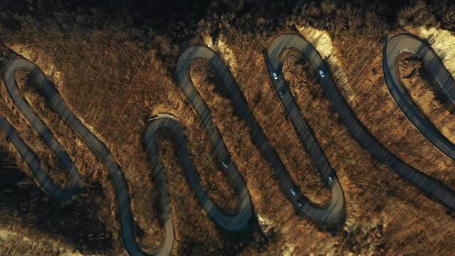 Curvy Road Concept: Aerial video of a scenic, S-shaped road full of curves, filmed by a drone in the fall. Emilia-Romagna, Italy