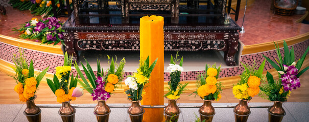 Beautiful buddha statue worship with flowers, incense sticks, candles in chapel, Thai temple.