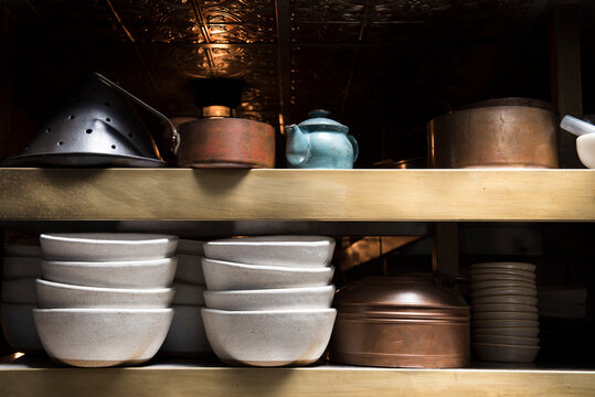 Shelf in restaurant with bowls and kettles