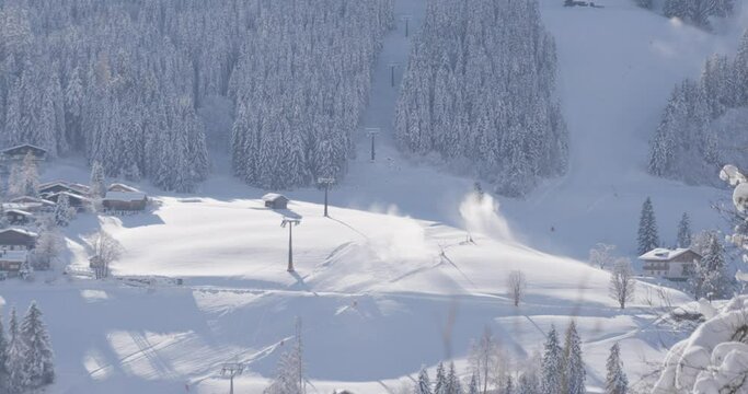 Snow cannons and a skilift in the austrian alps on a sunny day