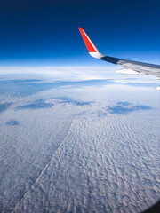 View of clouds and blue sky from an airplane window