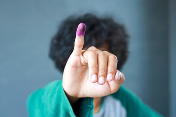 Man showing little finger after voting on Indonesia's presidential election - obrazy, fototapety, plakaty