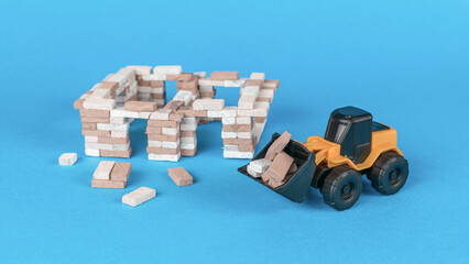 A bulldozer near a house under construction on a blue background.