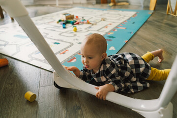 Cute baby girl playing with a toy on a play mat. Baby development.