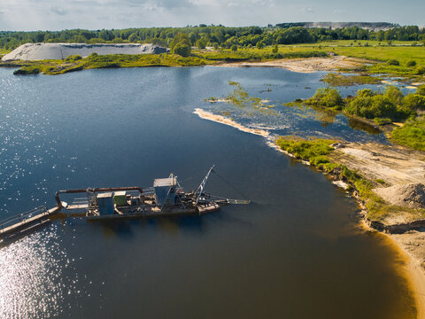 Suction dredger vessel works drawing up bottom mud on river
